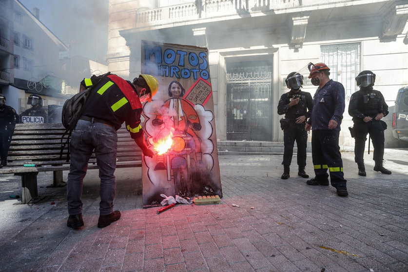 10 October 2021, Spain, Lugo: A demonstrator sets fire to a banner with a portrait of the Spanish Minister of Industry, Reyes Maroto, during a joint rally of workers of Alcoa and Vestas factories to against job cuts and to demand the prevention of the factories' shutdown. Photo: Carlos Castro/EUROPA PRESS/dpa