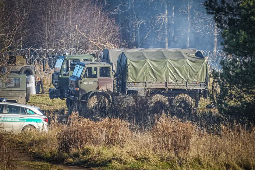 Polish army vehicles stand on the barbed wire border between Poland and Belarus near the Kusnica border crossing. The migration crisis at the Poland-Belarus border with refugees trying to enter the European Union via Belarus worsened on Monday, with Belarusian authorities saying that many hundreds of migrants had arrived at the border, and Poland reporting that some had already tried to break through. Photo: Michael Kappeler/dpa.