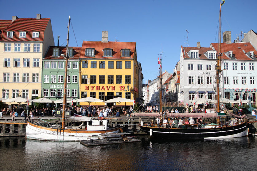 FILED - Passers-by walk along Nyhavn, in Copenhagen, the harbour with its colourful little houses popular with tourists. Denmark lifted Corona measures in force in the country on September 10 but plans to reintroduce some measures in November after cases climbed. Photo: Steffen Trumpf/dpa.