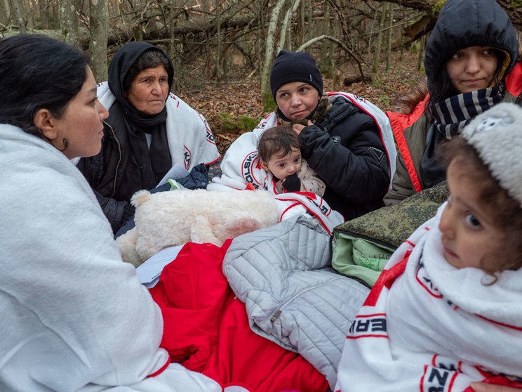 09 November 2021, Poland, Narewka: A refugee family warms themselves under blankets provided by Grupa Granica organization, as they sit in a forest near the Belarusian-Polish border. The Iraqi refugee family of seventeen, including nine children, called out to activists for help after spending seventeen days in a forest and got pushed back eight times. Photo: Jana Cavojska/SOPA Images via ZUMA Press Wire/dpa.