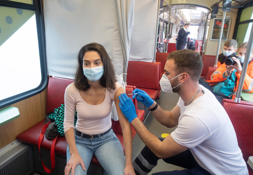 04 November 2021, Hessen, Frankfurt_Main: A woman gets her first vaccine jab inside the Vaccination Tram in Frankfurt. People who want to be vaccinated can board the tram, which runs on regular routes through Frankfurt, at any time without an appointment. Photo: Boris Roessler/dpa.