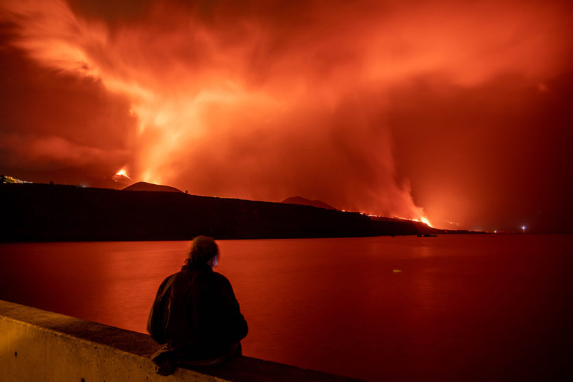FILED - 09 November 2021, Spain, La Palma: A person stands on the Los Guirres beach and watches lava flowing out of Cumbre Vieja volcano, during its eruption in La Palma on the Canary Islands. Photo: Kike Rincón/EUROPA PRESS/dpa.