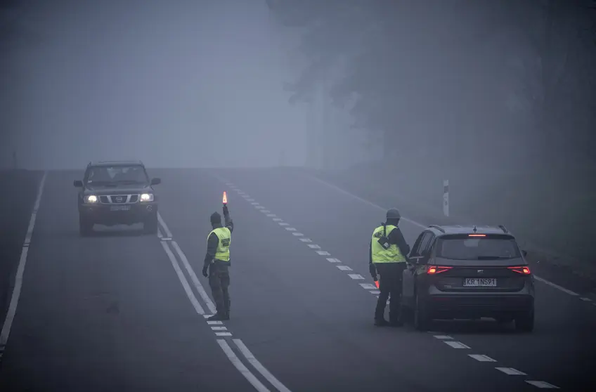 FILED - 11 November 2021, Poland, Kuznica: Police officers and military police check cars near the Kuznica border crossing on the border between Poland and Belarus. The migration crisis involving refugees trying to enter the European Union via Belarus has escalated on Poland's border with Belarus. Photo: Michael Kappeler/dpa.