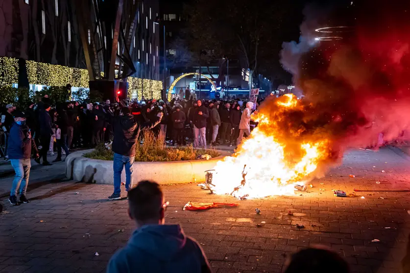 19 November 2021, Netherlands, Rotterdam: A scooter was set on fire during a protest against the 2G policy at the Coolsingel. Violent riots broke out in the Dutch port city of Rotterdam during a demonstration by hundreds of people against stricter anti-coronavirus measures. Photo: Killian Lindenburg/ANP/dpa.