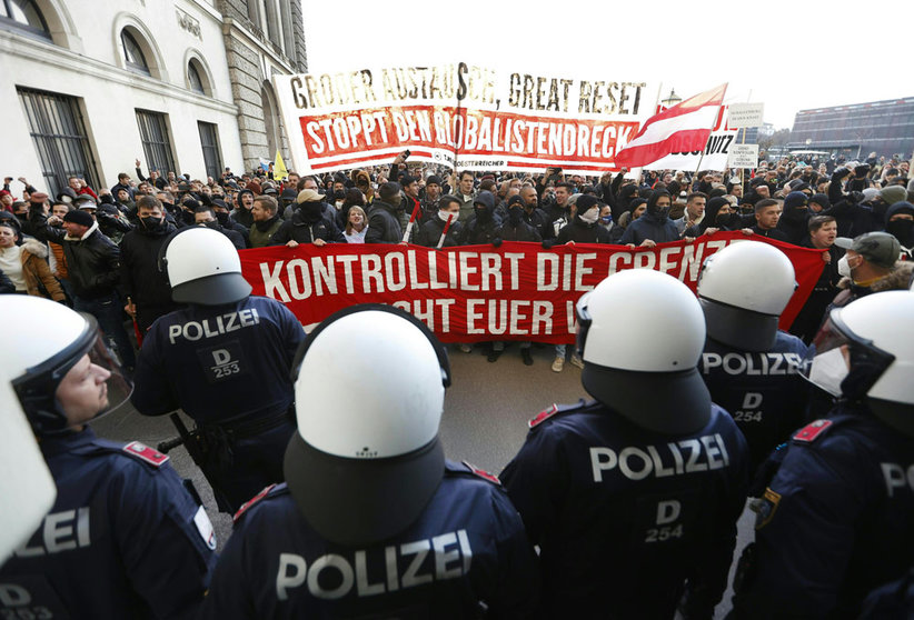 20 November 2021, Austria, Vienna: Policemen stand guard as people march down the Heldenplatz during a protest against the upcoming nationwide coronavirus lockdown. Photo: Florian Wieser/APA/dpa.
