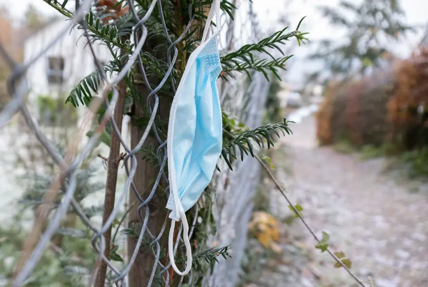 24 November 2021, Baden-Wuerttemberg, Stuttgart: A dangling mask is seen on a fence along a sidewalk in Stuttgart, Germany. Photo: Bernd Weißbrod/dpa.