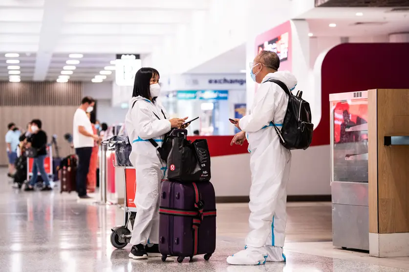 29 November 2021, Australia, Sydney: People wearing Personal Protective Equipment (PPE) arrivie at Sydney International Airport. The Omicron COVID-19 variant has arrived in Australia after testing confirmed two overseas travellers who arrived in Sydney were infected with the new strain. Photo: James Gourley/AAP/dpa.