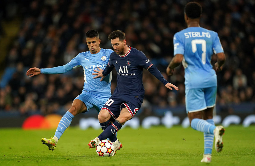 24 November 2021, United Kingdom, Manchester: Manchester City's Joao Cancelo (L) and Paris Saint-Germain's Lionel Messi battle for the ball during the UEFA Champions League Group A soccer match between Manchester City and Paris Saint-Germain at the Etihad Stadium. Photo: Martin Rickett/PA Wire/dpa.