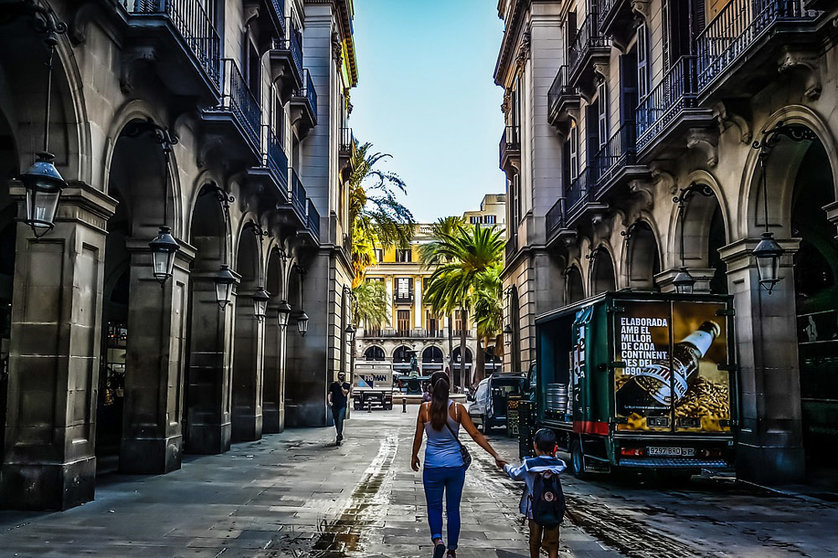 A woman walks with a child through the center of Barcelona. Photo: Pixabay.