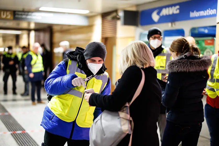 24 November 2021, Bavaria, Munich: An inspector of the Munich public transport company (MVG) checks the digital vaccination certificate of a woman at the entrance to the underground station at Stachus during a focal point inspection for compliance with the 3G rules in public transport (PNV). From Wednesday, those who want to travel by bus and train must be vaccinated, recovered or tested for Coronavirus. Photo: Matthias Balk/dpa.