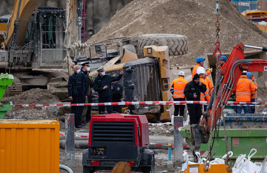 Police officers and railway employees stand next to an overturned wheel loader at a construction site after a WWII-era bomb detonated on Wednesday. Several people were injured in the explosion. Photo: Sven Hoppe/dpa.