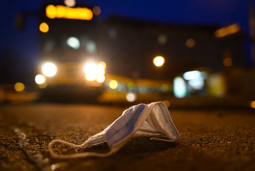 09 December 2021, Saxony, Dresden: A face mask lies on the ground at a tram stop, while in the background a tram of the Dresdner Verkehrsbetriebe (DVB) drives along. Photo: Robert Michael/dpa-Zentralbild/dpa.