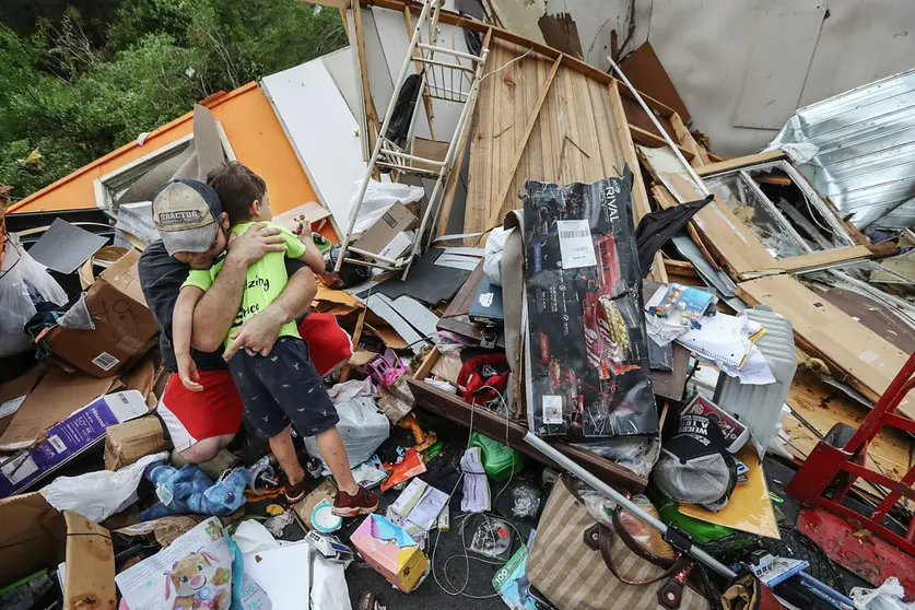 FILED - A man embraces his son among the rubble of their house after the family survived a deadly tornado that killed at least seven in Murray County, Georgia, in this file shot from December 11, 2020. Photo: Curtis Compton/TNS via ZUMA Wire/dpa.