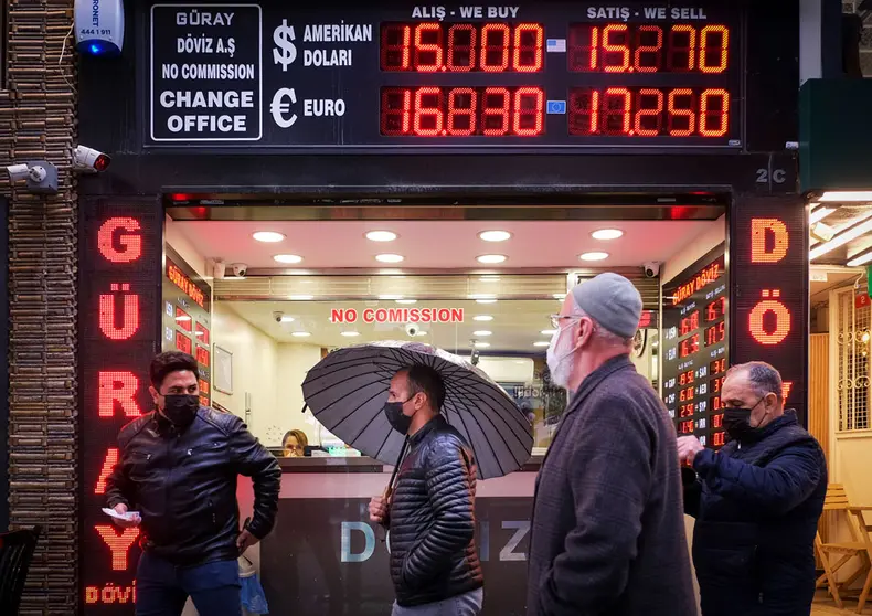 17 December 2021, Turkey, Istanbul: People walk in front of a currency exchange shop in Istanbul. The Turkish central bank cut its benchmark interest rate to 14 per cent on Thursday, the fourth consecutive cut since September, leading the lira to fall to historic lows. Photo: Serkan Senturk/ZUMA Press Wire/dpa.