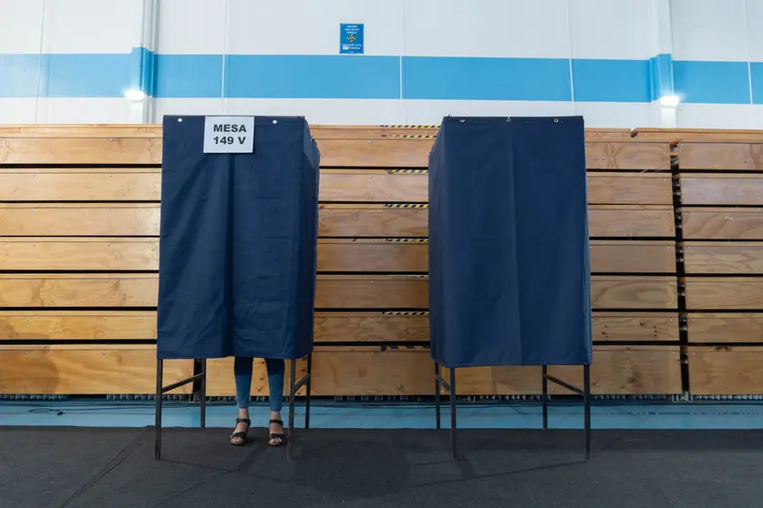 19 December 2021, Chile, Santiago: A voter stands behind a polling booth at a polling station in Santiago during the second round of the presidential election. Chileans have to choose their next president between the right-wing politician Jose Antonio Kast and the former student leader Gabriel Boric. Photo: Matias Basualdo/ZUMA Press Wire/dpa.