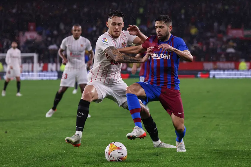 21 December 2021, Spain, Sevilla: Barcelona's Jordi Alba (R) and Sevilla's Lucas Ocampos battle for the ball during the Spanish La Liga soccer match between Sevilla and Barcelona at Ramon Sanchez-Pizjuan Stadium. Photo: Jose Luis Contreras/DAX via ZUMA Press Wire/dpa.