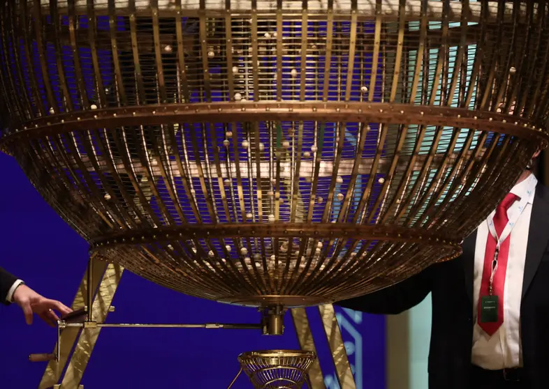 22 December 2021, Spain, Madrid: Preparing the lottery drum and the wooden balls with the ticket numbers shortly before the drawing of the 2021 Christmas lottery in the Teatro Real opera house. Photo: Eduardo Parra/EUROPA PRESS/dpa.