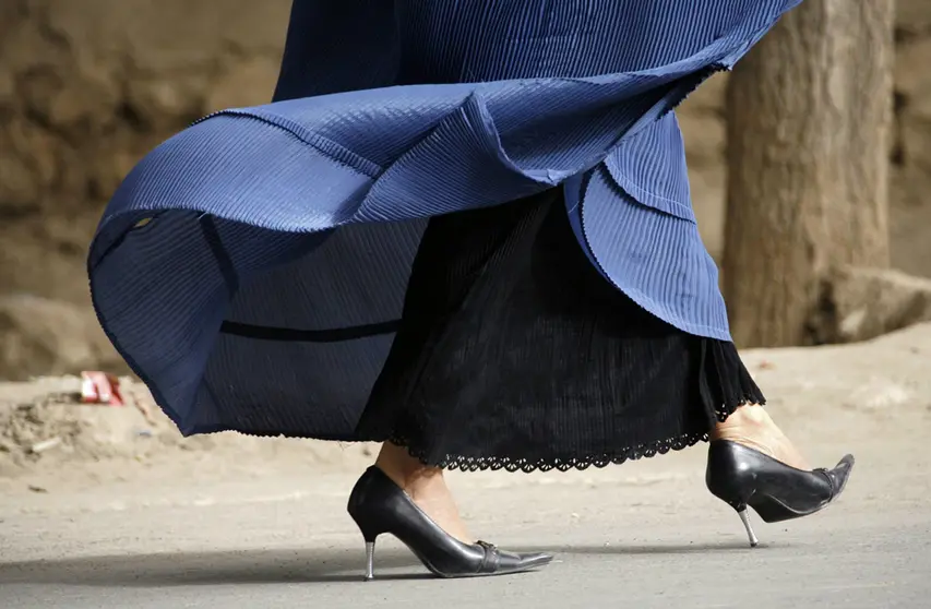 FILED - 30 September 2008, Afghanistan, Taleqan: A women wearing high heels and a burka walks along a street in Taloquan. Taliban religious police in Afghanistan have directed all drivers to refrain from playing music in their cars and not to pick up female passengers who do not follow the Islamic dress code. Photo: Maurizio Gambarini/dpa.