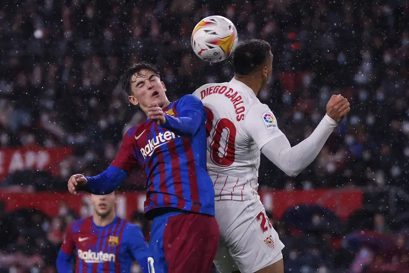 21 December 2021, Spain, Sevilla: Barcelona's Gavi (L) and Sevilla's Diego Carlos battle for the ball during the Spanish La Liga soccer match between Sevilla and Barcelona at Ramon Sanchez-Pizjuan Stadium. Photo: Jose Luis Contreras/DAX via ZUMA Press Wire/dpa.