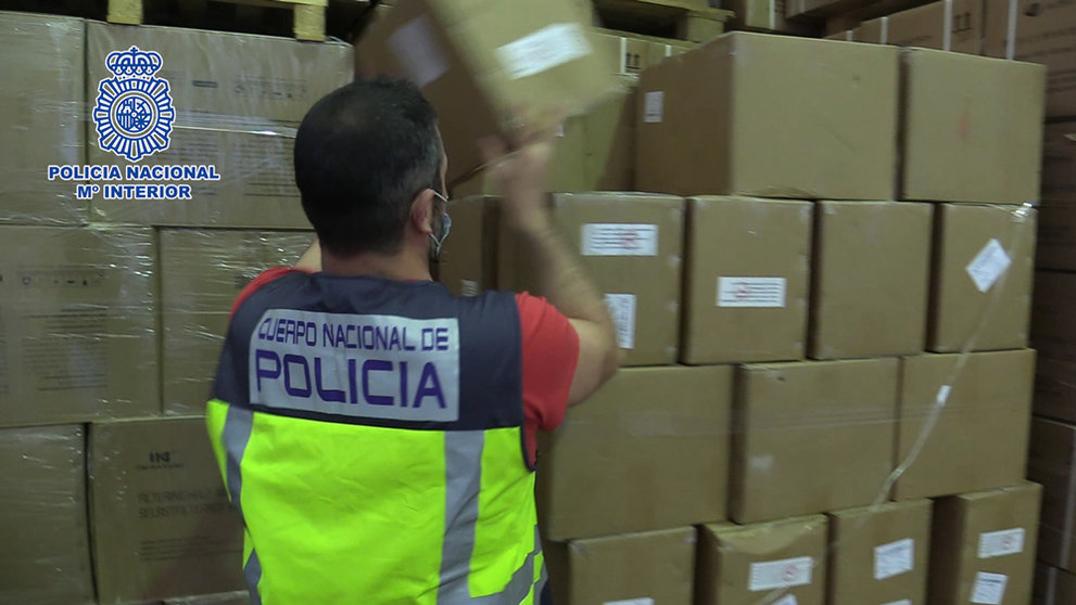 A police officer examines the seized antigen tests. Photo: Policia Nacional