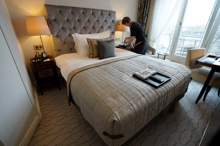 FILED - 30 November 2021, Hamburg: An employee of the luxury hotel "Vier Jahreszeiten" prepares a room for the next hotel guests. The restrictions imposed on public life to combat the Corona pandemic have hit the tourism sector in Germany hard for the second year in a row. Photo: Marcus Brandt/dpa.