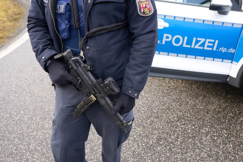 31 January 2022, Rhineland-Palatinate, Kusel: Police officers block the access road to the scene where two police officers were fatally wounded by gunfire during a traffic stop. The fatal shootings occurred during a routine traffic stop, according to police. Photo: Thomas Frey/dpa.