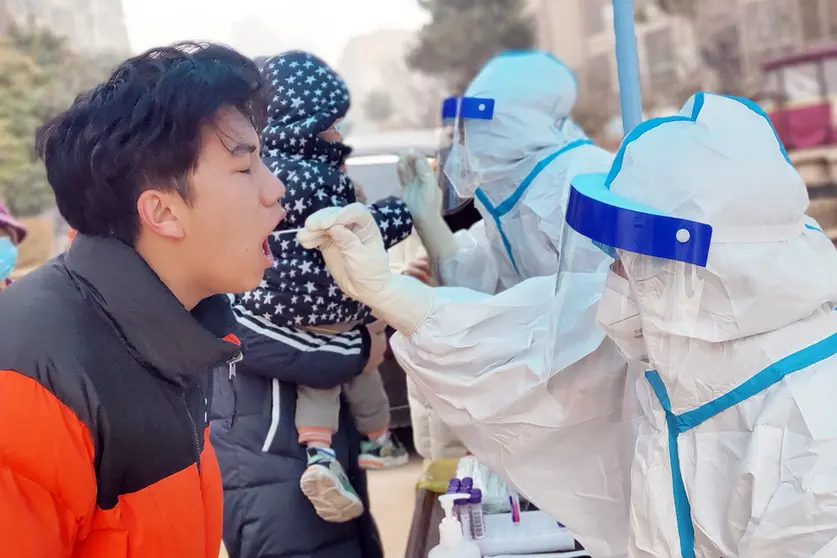 10 January 2022, China, Anyang: Health workers take swabs for the Covid-19 test from residents of Huatong Century City Community in the sealed area of Hua county, Anyang City. China records 157 new confirmed cases of the corona, 97 of which are local. Photo: Wang Zirui/SIPA Asia via ZUMA Press Wire/dpa.