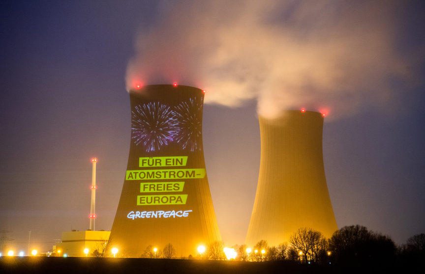 dpatop - 2021: A projection by the environmental protection organization Greenpeace shines on the German nuclear power plant Grohnde (long exposure). A debate has flared up in the EU about the climate impact of nuclear power plants. Photo: Julian Stratenschulte/dpa.