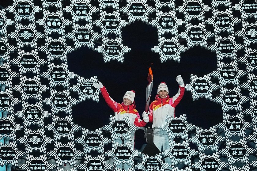 04 February 2022, China, Beijing: Chinese nordic combined skiier Zhao Jiawen (L) and Yilamujiang Dinigeer light the Olympic Cauldron during the opening ceremony of the Beijing 2022 Winter Olympics at the Bird's Nest National Stadium. Photo: Michael Kappeler/dpa.