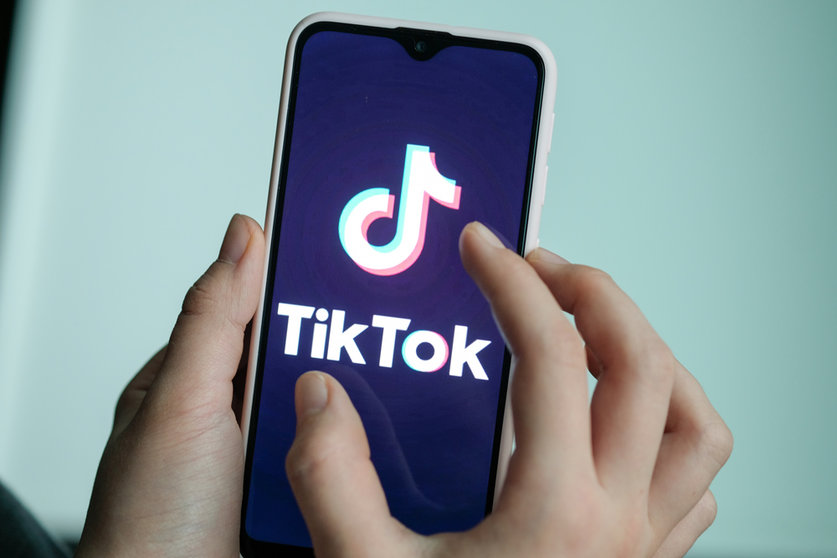 FILED - 13 November 2019, Berlin: A girl holds her smartphone with the logo of the short video app TikTok. Social media platform TikTok has lodged a legal objection through the German courts to a requirement that it pass on large quantities of user data to the country's federal police, a spokeswoman for the administrative court in Cologne said on Thursday. Photo: Jens Kalaene/dpa-Zentralbild/dpa.