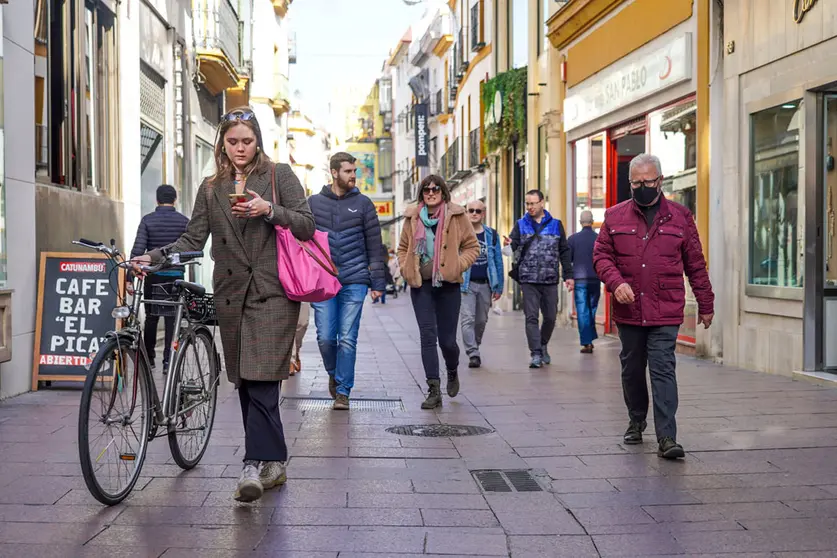 10 February 2022, Spain, Seville: A woman without a mask walks her bicycle along a street in Seville. The Spanish health authorities have lifted the mask requirement outdoors as case numbers fall. Photo: Eduardo Briones/EUROPA PRESS/dpa.