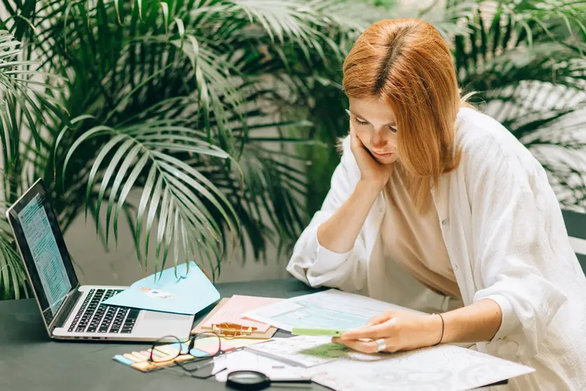 IRPF income tax woman red hair work laptop. Photo: Pexels.