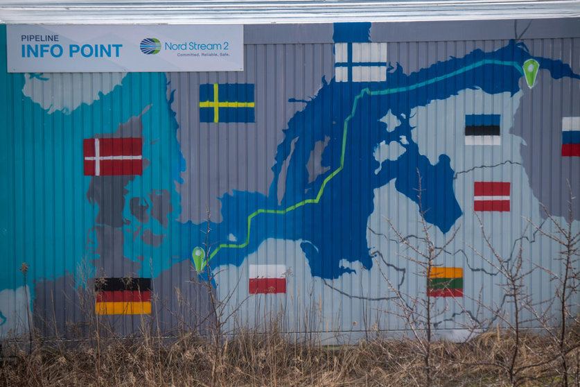 22 February 2022, Mecklenburg-Western Pomerania, Lubmin: A sign reading "Nord Stream 2 Committed. Reliable. Safe." hangs above a painted map on an information container for the Nord Stream 2 gas pipeline at the Lubmin industrial park. The German government is halting the approval process for the Nord Stream 2 gas pipeline in light of developments in the Ukraine conflict, government sources told dpa. Photo: Stefan Sauer/dpa.