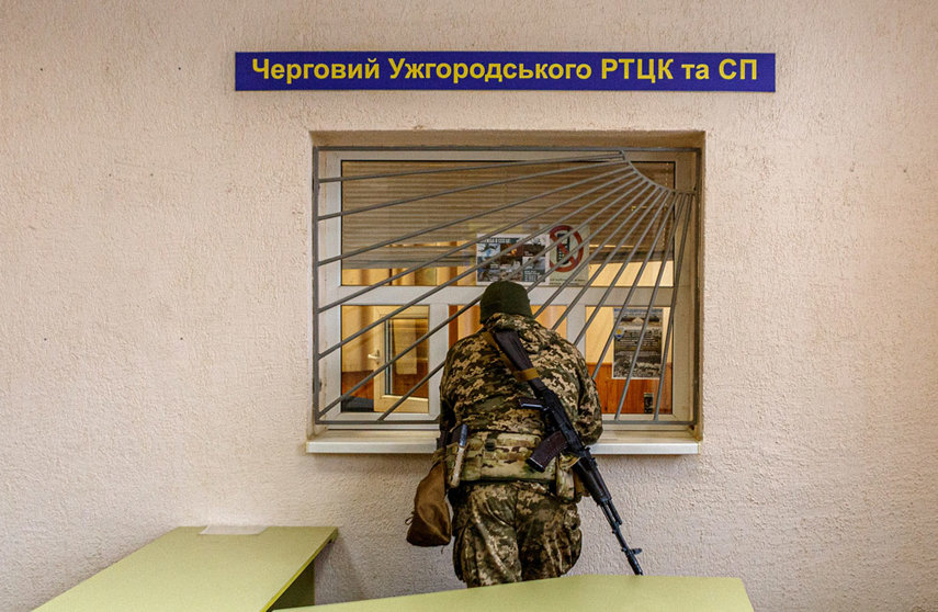 25 February 2022, Ukraine, Uzhhorod: An armed man in a camouflage uniform is pictured at the Zakarpattia Regional Territorial Centre for Staffing and Social Support, on the second day of the Russian invasion of Ukraine. Photo: -/Ukrinform/dpa.