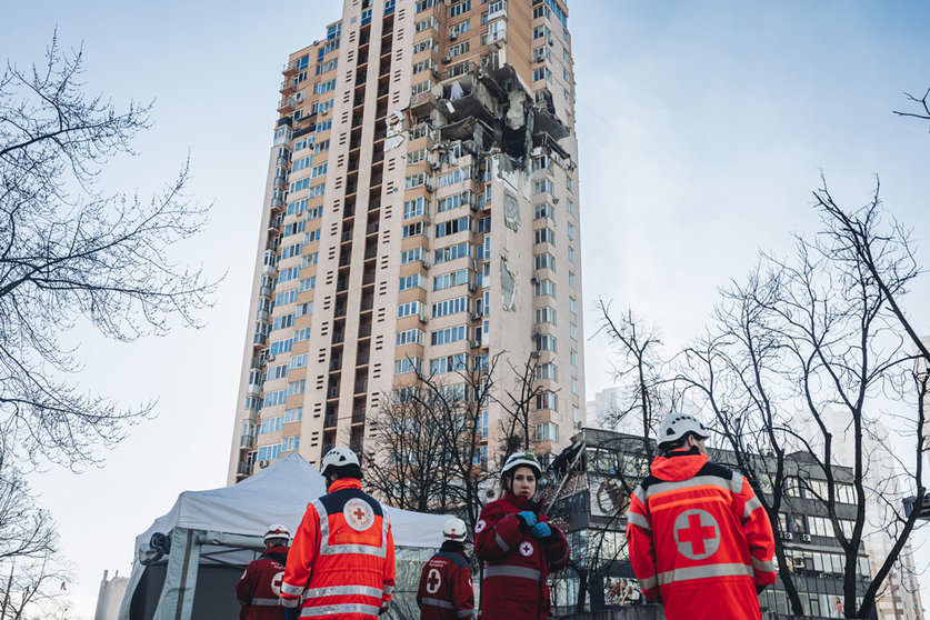 26 February 2022, Ukraine, Kiev: Emergency services stand in front of a multi-storey residential building in Kiev that was hit by a rocket on the third day of the Russian invasion of Ukraine. Photo: Diego Herrera/EUROPA PRESS/dpa