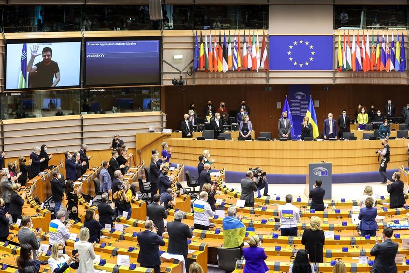HANDOUT - 01 March 2022, Belgium, Brussels: Ukrainian President Volodymyr Zelensky (on screen) is applauded as he addresses members of the European Parliament via video conference during an extraordinary plenary session of the European Parliament on the situation in Ukraine after the Russian invasion. Photo: Alain Rolland/EU Parliament/dpa - ATTENTION: editorial use only and only if the credit mentioned above is referenced in full.