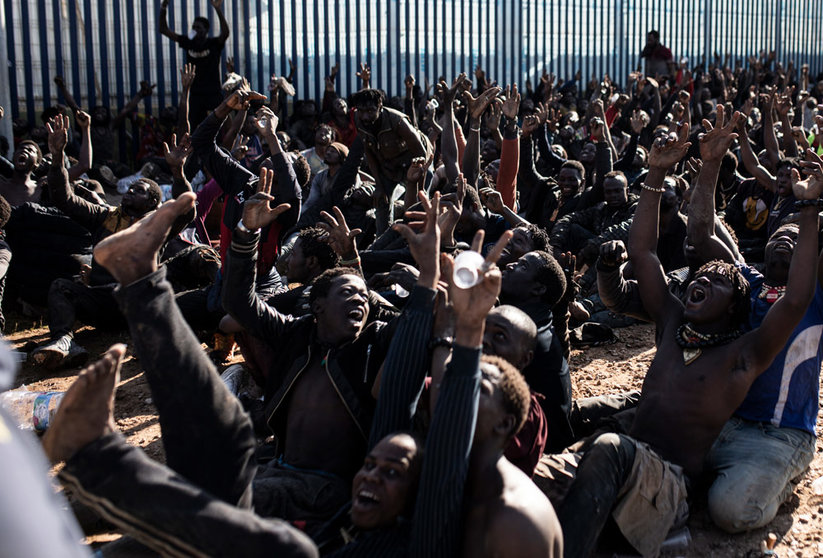 02 March 2022, Spain, Melilla: Migrants cheer after they managed to jump the border fence of Melilla. According to Guardia Civil sources, up to 2,000 people of sub-Saharan origin have attempted to cross the Melilla border fence, of which 500 have succeeded and made their way to the Temporary Immigrant Stay Center (CETI). Photo: Ilies Amar/EUROPA PRESS/dpa.
