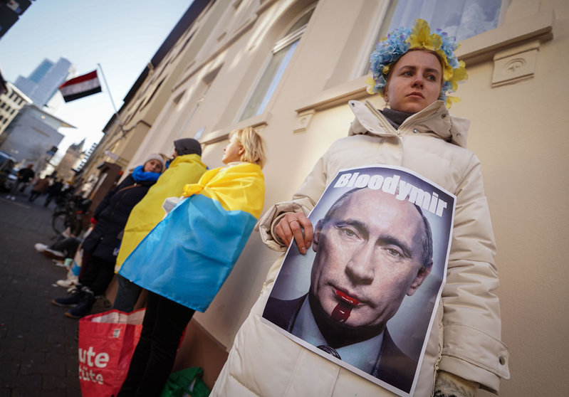 03 March 2022, Hessen, Frankfurt_Main: Oleksandra (27), from Kiev, holds an anti-Putin poster during a vigil in front of the Russian consulate in Frankfurt-Main against the Russian invasion of Ukraine. Photo: Frank Rumpenhorst/dpa.