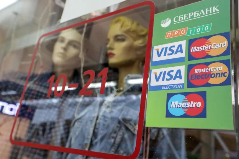 06 March 2022, Russia, Saint Petersburg: The logos of various payment systems with Sberbank written on them are pasted on a window of a store. Russia's largest bank - Sberbank - wants to ensure that people can pay and withdraw money with their cards even after Visa and Mastercard credit cards are switched off. Photo: Igor Russak/dpa.