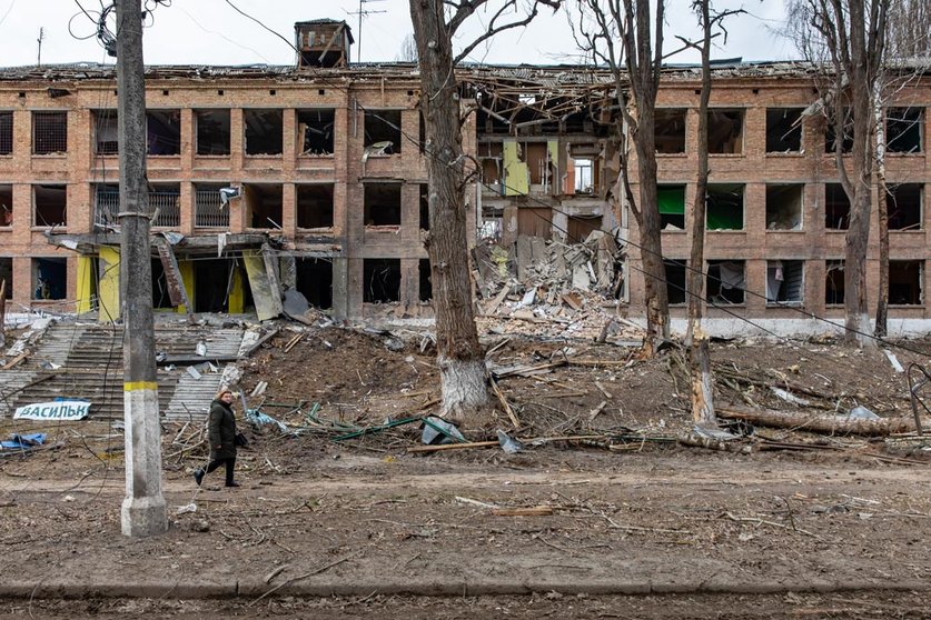 07 March 2022, Ukraine, Vasylkiv: A woman walks past a damaged secondary school building after shelling by Russian forces. Attacks and fighting continued 13 days after the Russian invasion. Photo: Mykhaylo Palinchak/SOPA Images via ZUMA Press Wire/dpa.