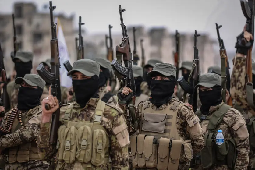 17 February 2022, Syria, Idlib city: Fighters from the Popular Resistance Brigades take part in a military parade in Idlib city during their graduation from a military course in the presence of the Prime Minister of the Syrian Salvation Government. Photo: Anas Alkharboutli/dpa.