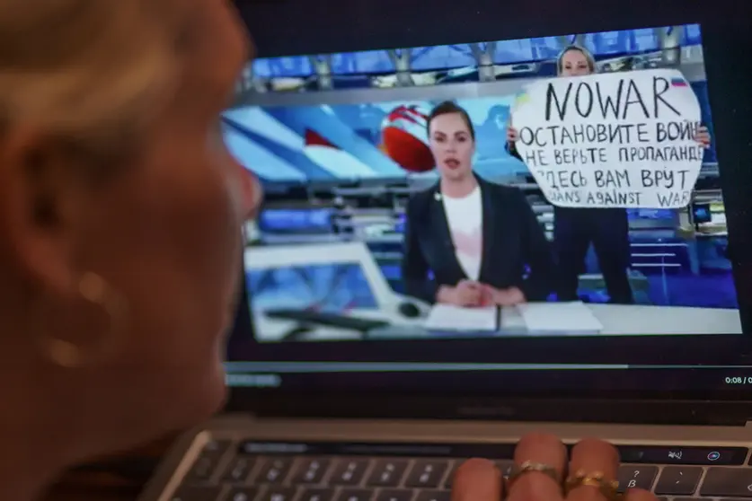 FILED - 14 March 2022, Hamburg: A person watches on a monitor a scene from the main evening news broadcast on Russian state television, as it is interrupted by an anti-war protester. Photo: Axel Heimken/dpa.