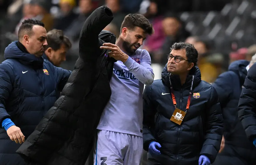 07 April 2022, Hessen, Frankfurt/M.: Barcelona's Gerard Pique puts on a jacket after leaving the pitch with an injury during the UEFA Europa League quarterfinal first leg soccer match between Eintracht Frankfurt and FC Barcelona at Deutsche Bank Park. Photo: Arne Dedert/dpa.