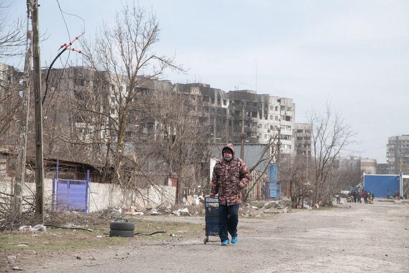 29 March 2022, Ukraine, Mariupol: A woman makes her way out of Mariupol on foot after heavy bombardment left much of the city in ruins. The battel between Russian/Pro Russian forces and the defencing Ukrainian forces lead by Azov battalion continues in the port city of Mariupol. Photo: Maximilian Clarke/SOPA Images via ZUMA Press Wire/dpa.