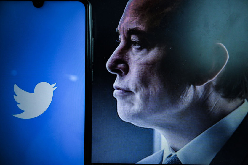 25 April 2022, France, Clermont-Ferrand: A view of the logo of the American social networking company Twitter on a smartphone screen beside a Portrait of the entrepreneur Elon Musk. Shares of Twitter, Inc are rising almost 5% in pre-market on Monday after reports that the microblogging site's board is set to accept an offer from Tesla founder Elon Musk as early as Monday. Photo: Adrien Fillon/ZUMA Press Wire/dpa.