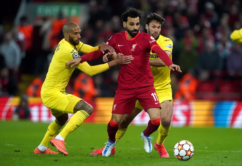 27 April 2022, United Kingdom, Liverpool: Liverpool's Mohamed Salah battles for the ball with Villarreal’s Etienne Capoue (L) and Alfonso Pedraza during the UEFA Champions League semi final, first leg soccer match between Liverpool and Villarreal CF at Anfield. Photo: Peter Byrne/PA Wire/dpa.