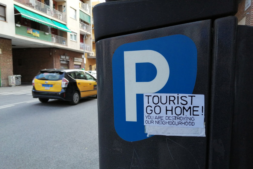 A sticker on a parking payment machine in the Barceloneta neighborhood in Barcelona shows rejection against tourists. Photo: © The Nomad Today.