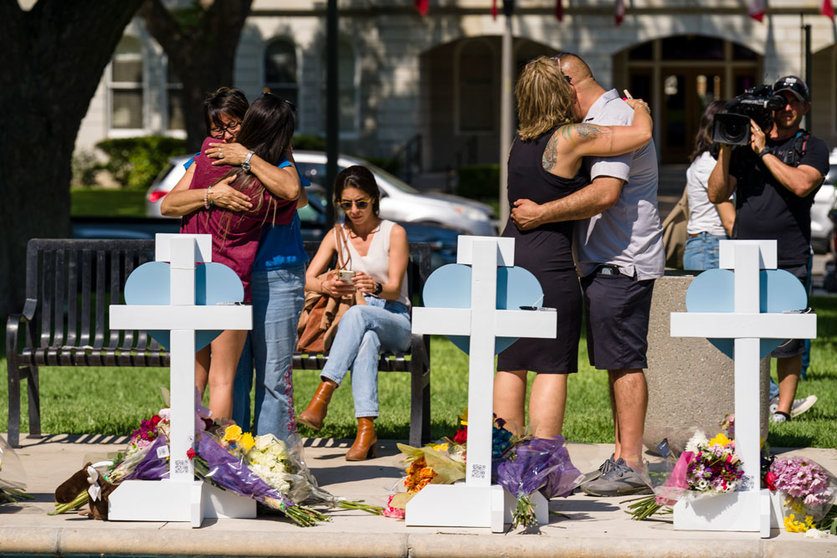 26 May 2022, US, Uvalde: Mourners visit a memorial for victims of Tuesday's mass shooting at Robb Elementary School. An 18-year-old had broken into the school and opened fire on children and adults. At least 19 children died and a teacher was also killed. Photo: Jintak Han/ZUMA Press Wire/dpa.