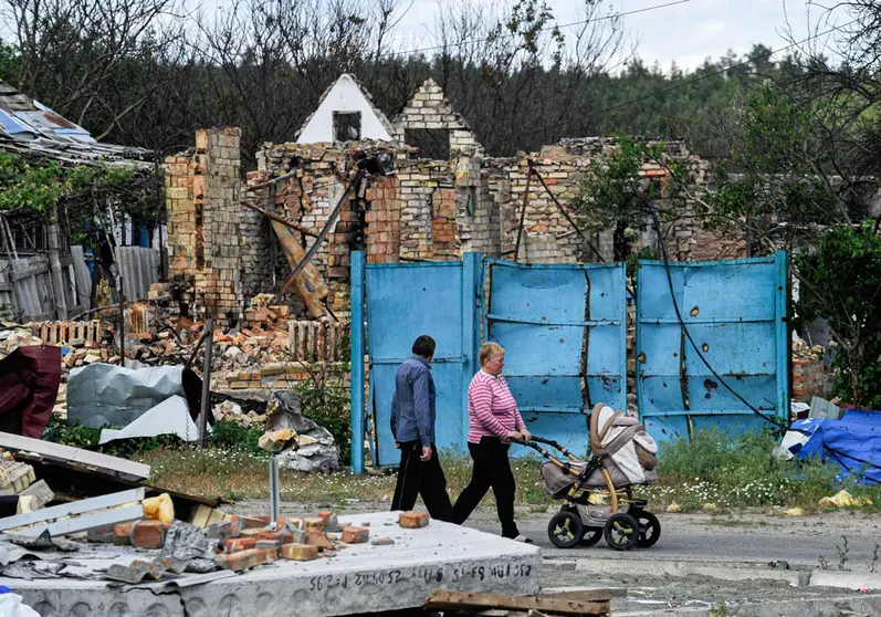 29 May 2022, Ukraine, Mykhailivka-Rubezhivka: People walk past a house destroyed by Russian shelling at Mykhailivka-Rubezhivka village near the Ukrainian capital Kiev. Photo: Sergei Chuzavkov/SOPA Images via ZUMA Press Wire/dpa.