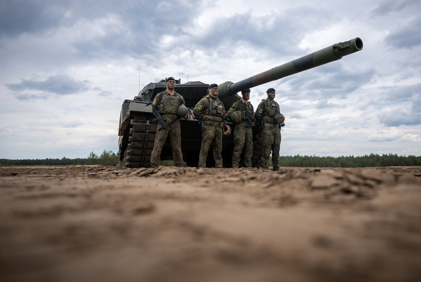 07 June 2022, Lithuania, Pabrade: Soldiers stand in front of a German Army Leopard-2 tank used by the NATO Enhanced Forward Presence Battle Group (eFP battalion) during a visit by German Chancellor Olaf Scholz to Camp Adrian Rohn. Photo: Michael Kappeler/dpa.